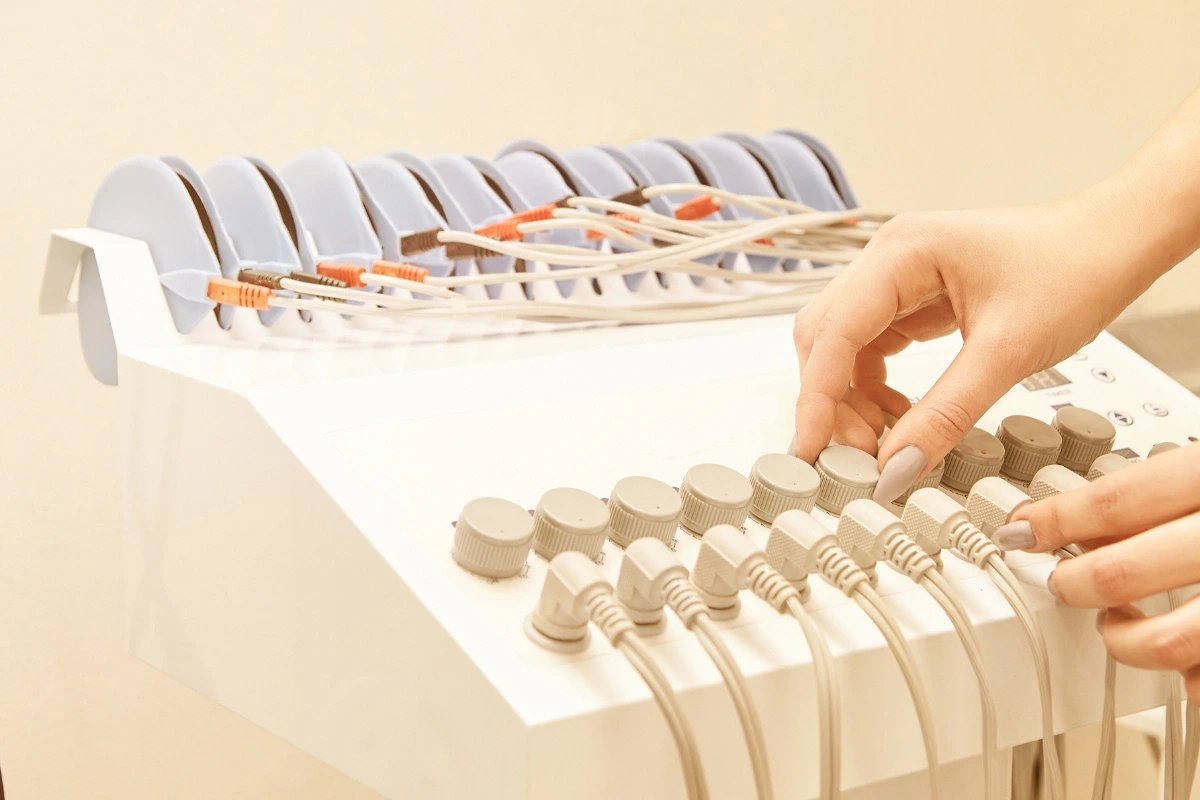 Detail rúk obsluhujúcich prístroj na elektrostimuláciu.