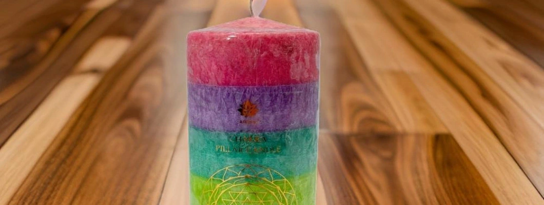 Sviečka s farbami symbolizujúcimi čakry.