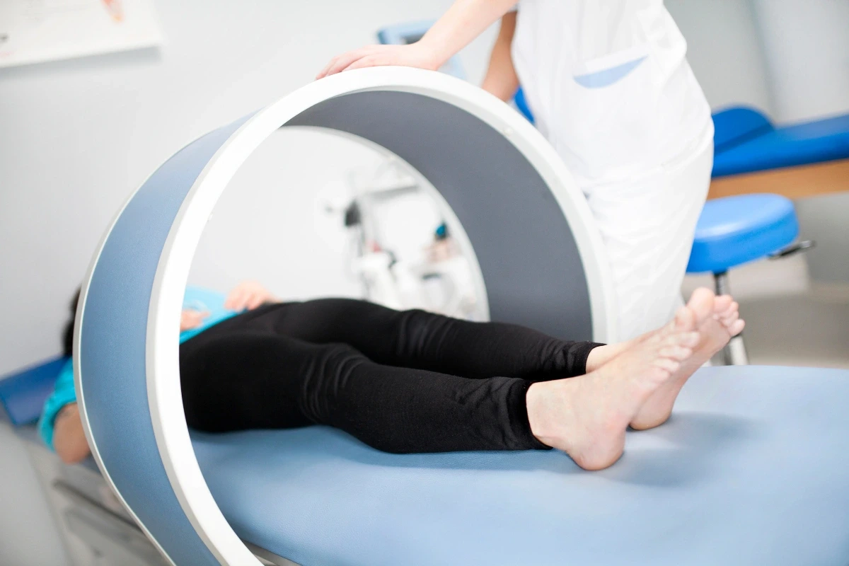 Nohy pacientky vo valcovom aplikátore počas pulznej magnetoterapie.